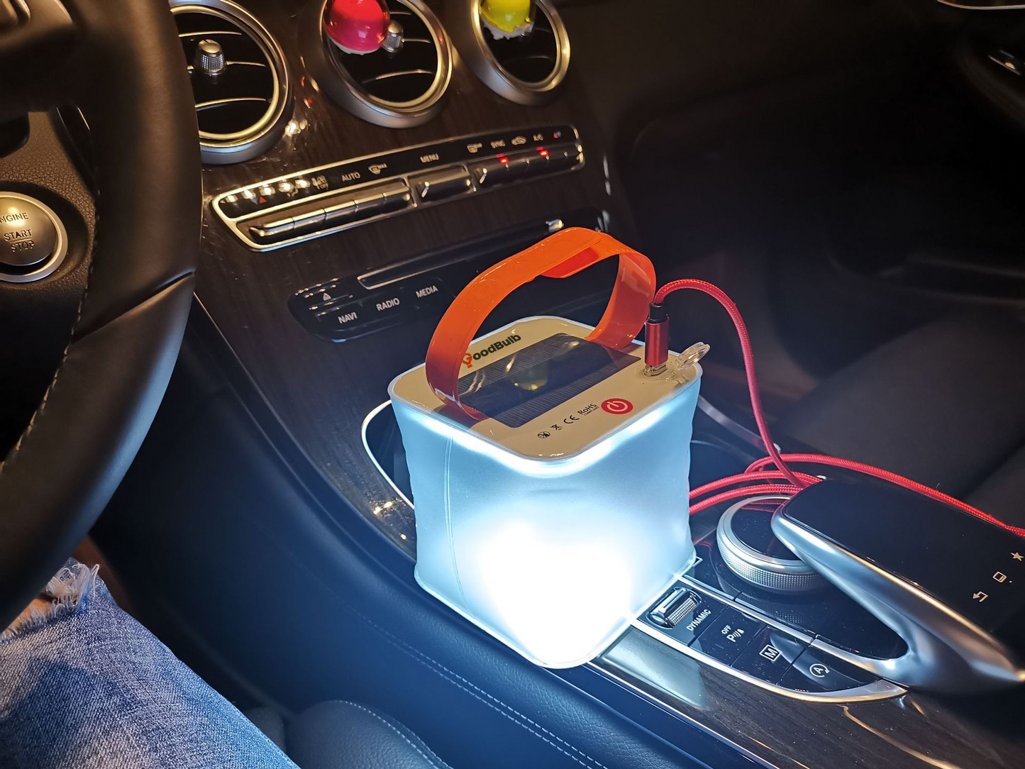 Inflatable Solar portable lantern with cell phone charging kit being used in a car demonstration.